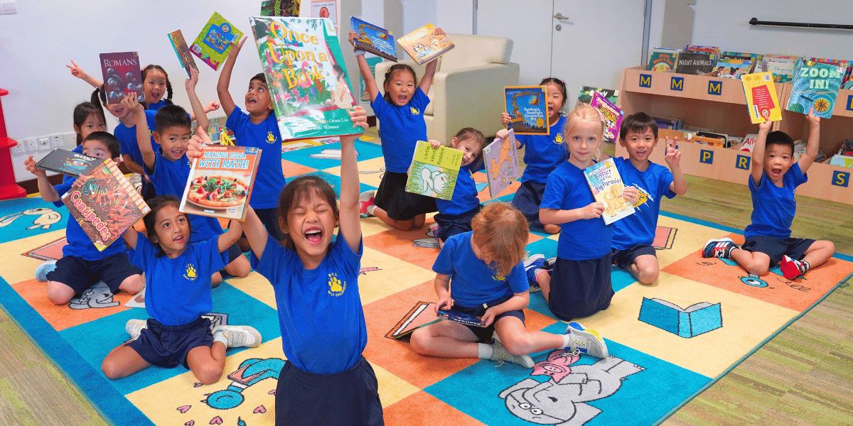 クアラルンプール・インターナショナルスクール: A group of young students are enthusiastically engaged in various activities and creative projects within a vibrant and colorful classroom environment.
